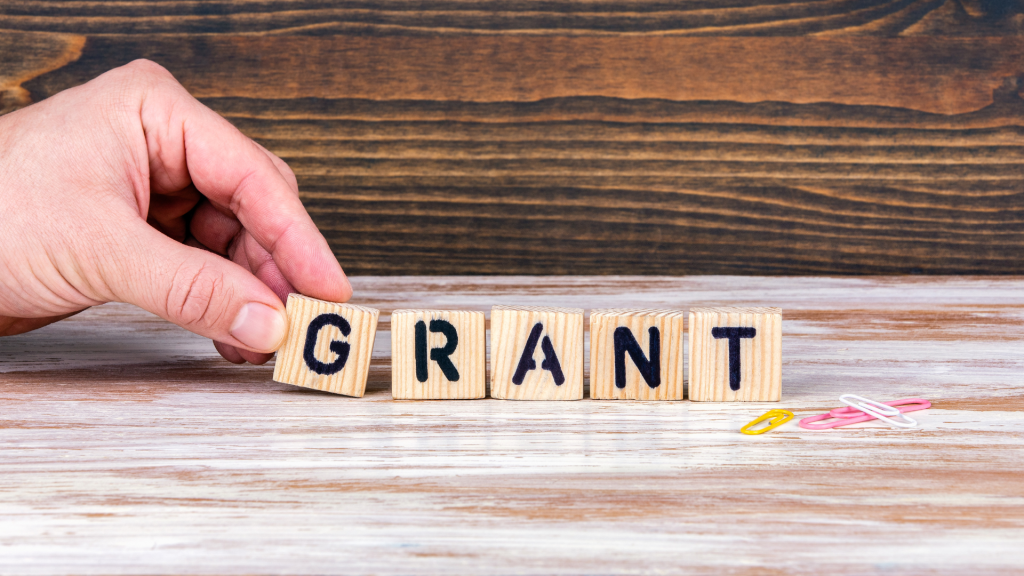 Dłoń układająca litery w słowo: Grant